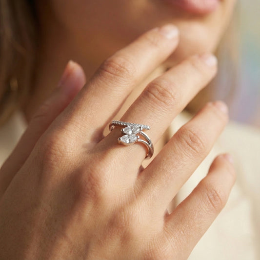 Close-up of a hand wearing a silver ring with a butterfly design.