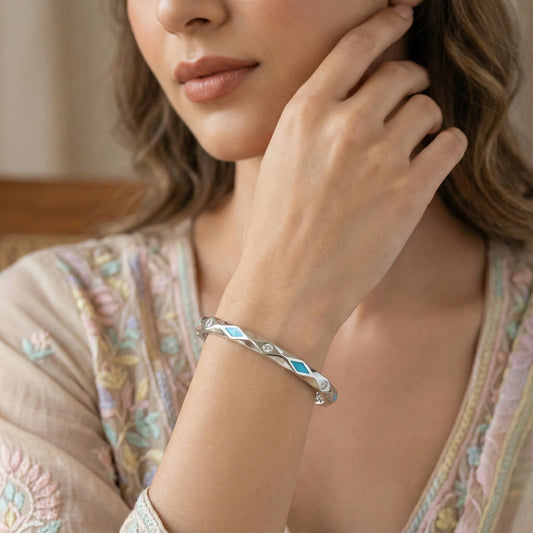 Woman wearing a silver bracelet with blue stones, close-up on hand and wrist.