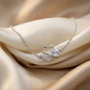 Silver swan necklace with a heart-shaped pendant on beige fabric