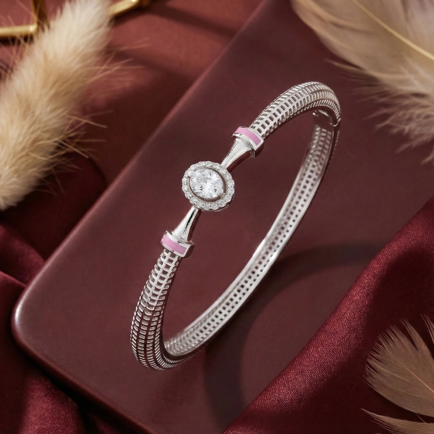 Silver bracelet with pink accents on a maroon fabric background