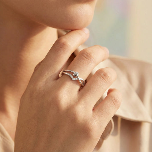 Close-up of a hand wearing a silver ring with a blue gemstone, against a soft blurred background.