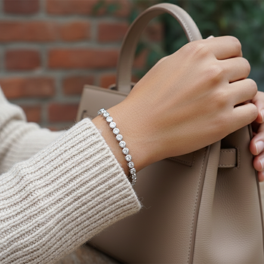 Hand holding a beige handbag with a blurred brick wall background