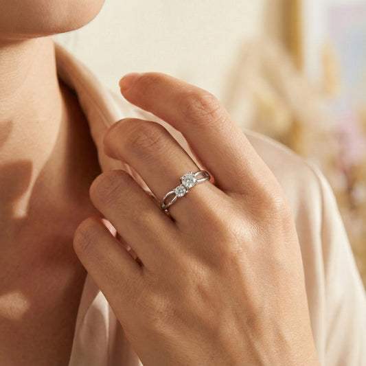 Close-up of a hand wearing a silver ring with a diamond on a blurred background