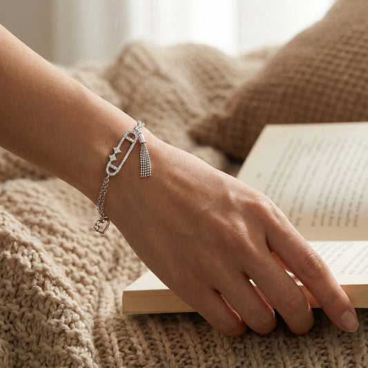 Hand wearing a silver bracelet on a textured surface with a book