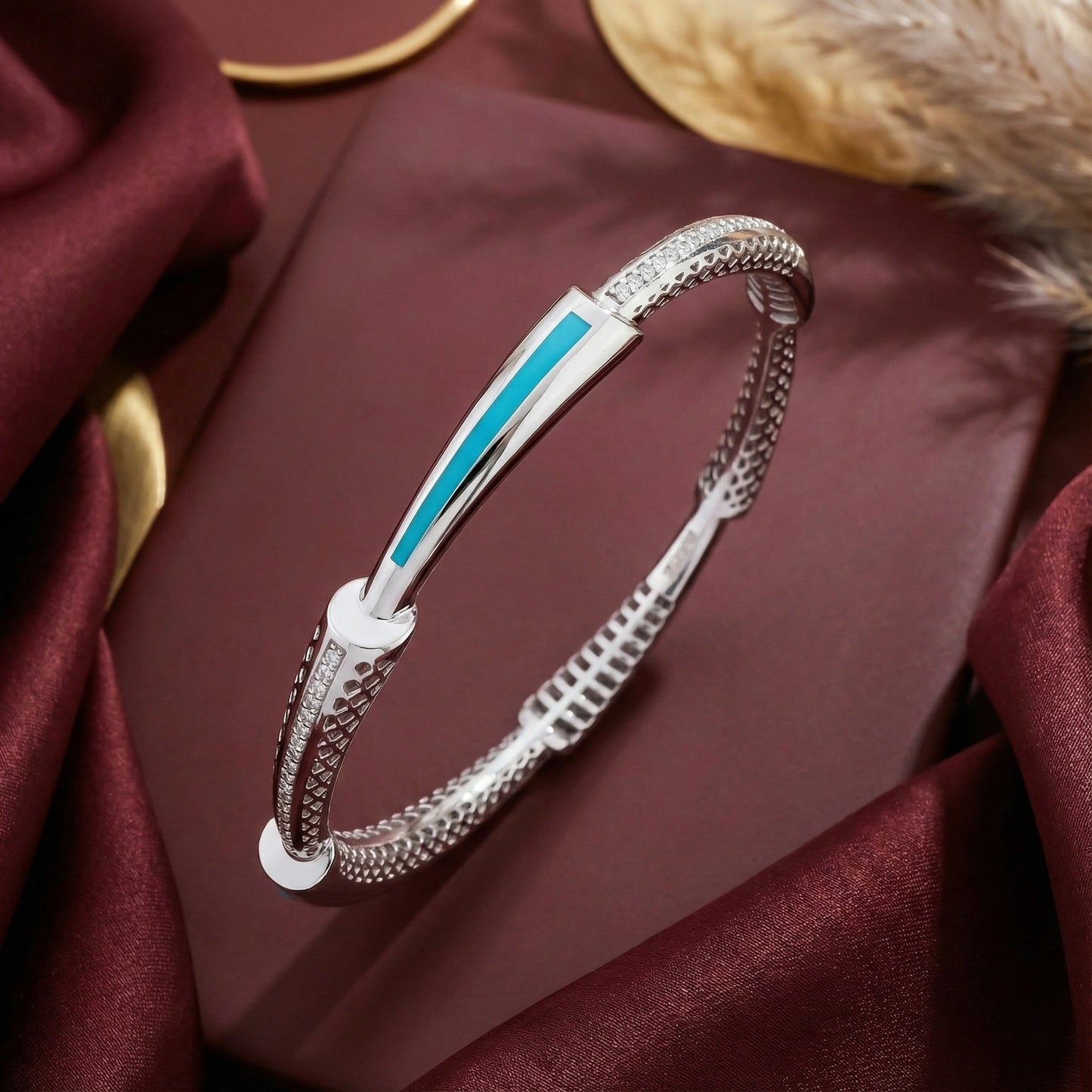 Silver bracelet with blue accent on a burgundy fabric background