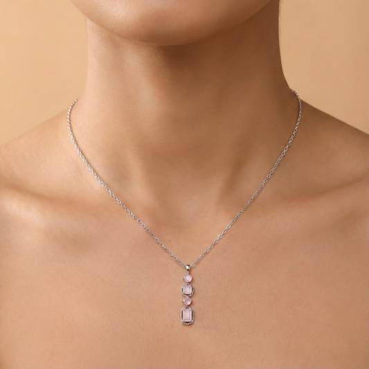 Necklace with a pink pendant on a person against a beige background
