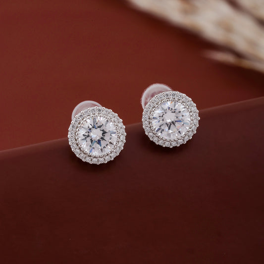 Pair of diamond stud earrings on a brown surface