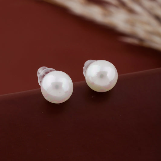 Pair of pearl earrings on a brown surface