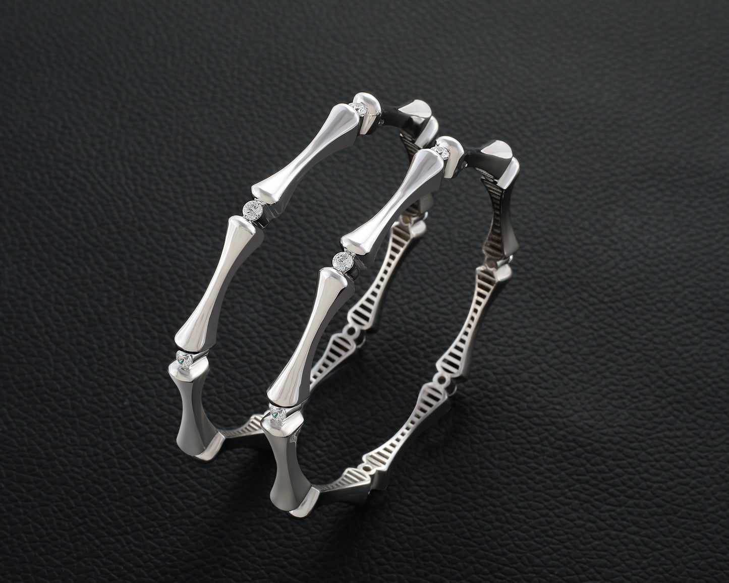 Silver bracelet with bone-like design on a dark textured background