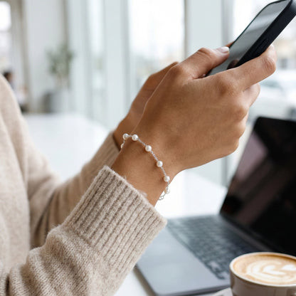 Minimal pearl station bracelet in 925 silver on dark stone background