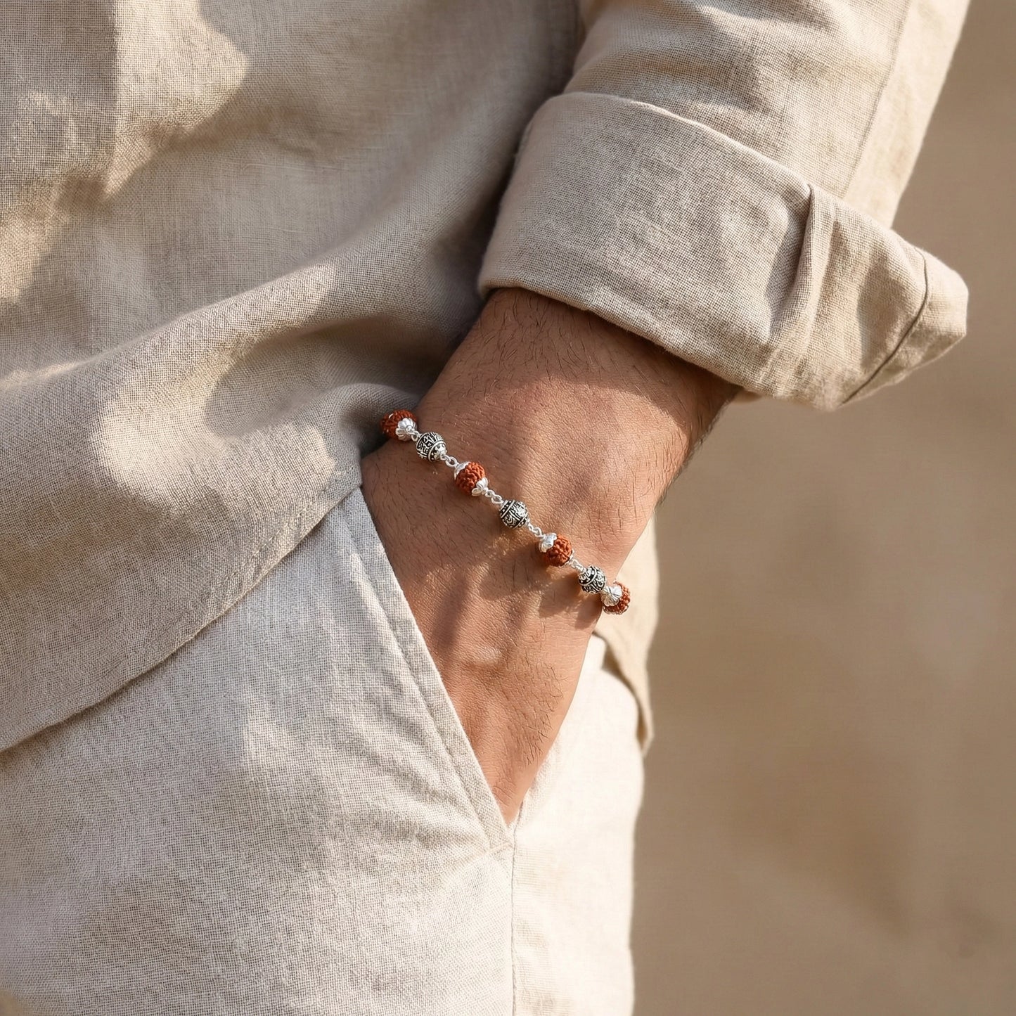 the bracelet features polished silver casting balls alternated with natural Rudraksha beads