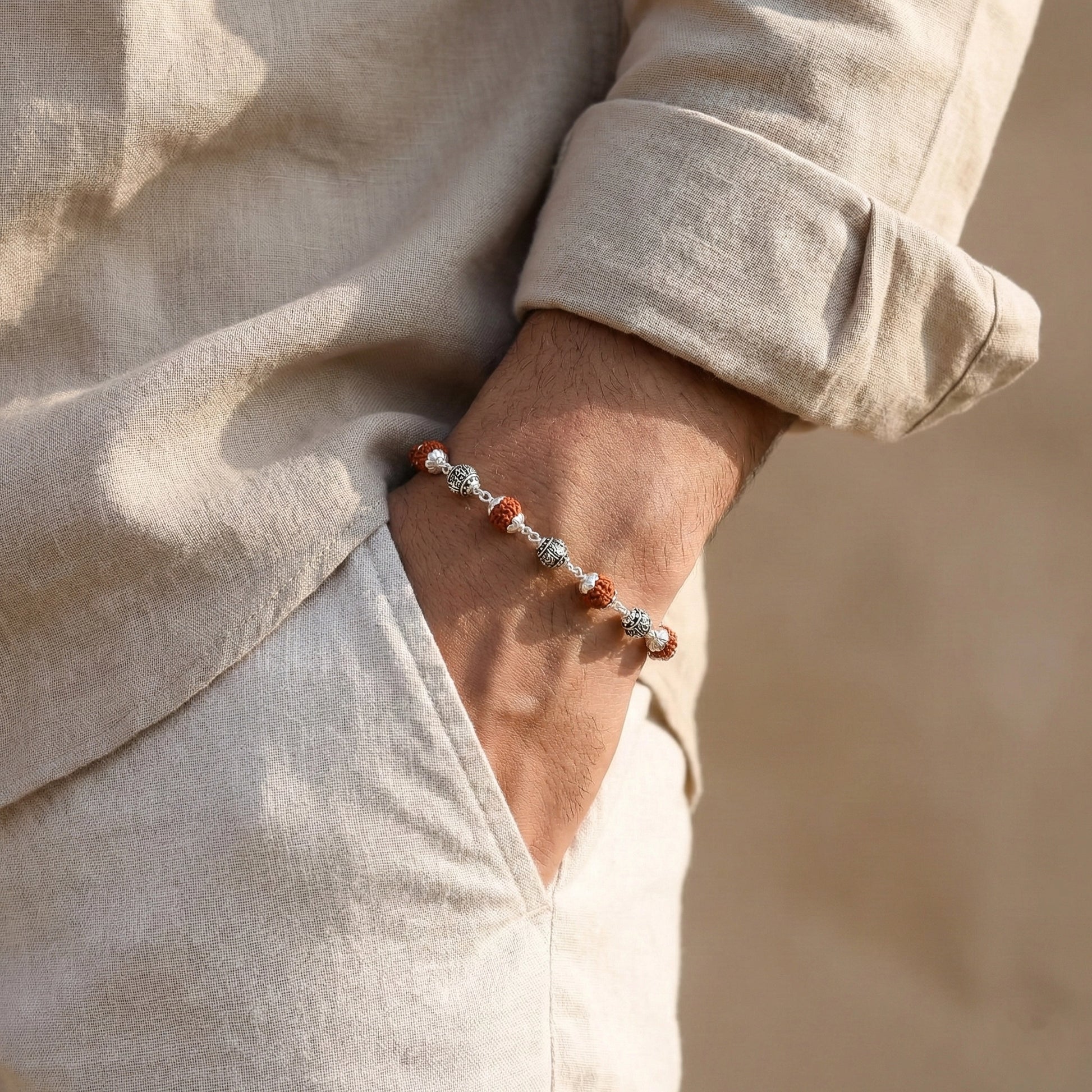 the bracelet features polished silver casting balls alternated with natural Rudraksha beads