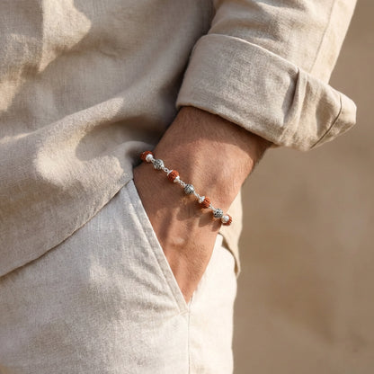 the bracelet features polished silver casting balls alternated with natural Rudraksha beads