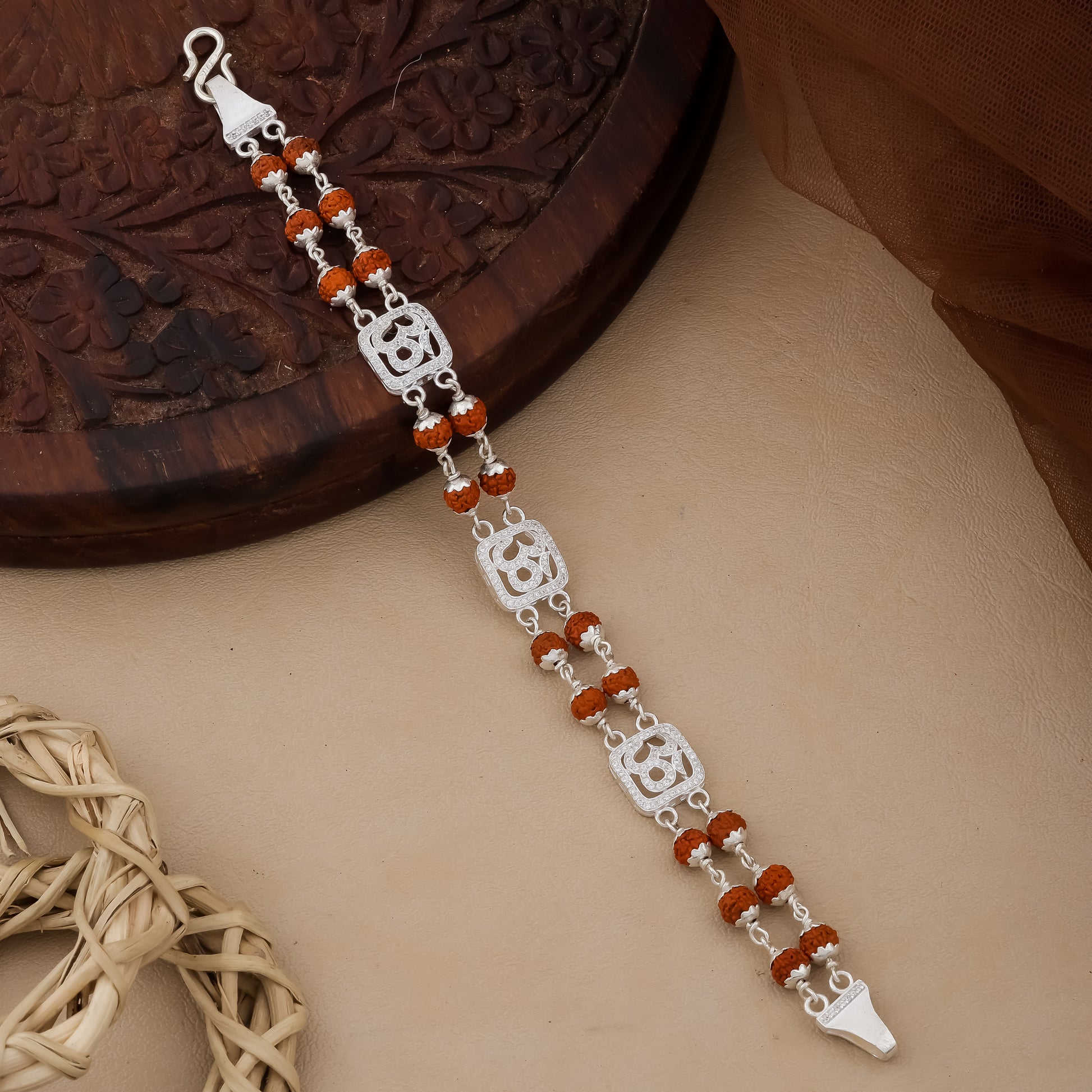 Silver bracelet with red beads on a textured surface