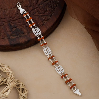 Silver bracelet with red beads on a textured surface