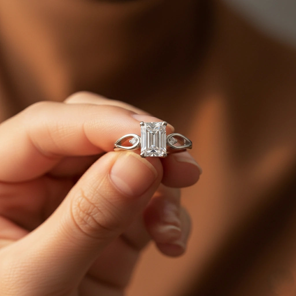 Hand holding a diamond ring with a blurred background