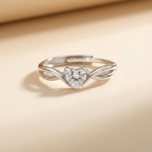 Silver heart-shaped ring on a beige background