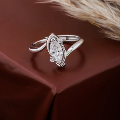 Silver ring with a diamond on a brown fabric background