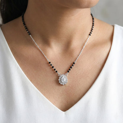 Necklace with a pendant worn by a person in a white top