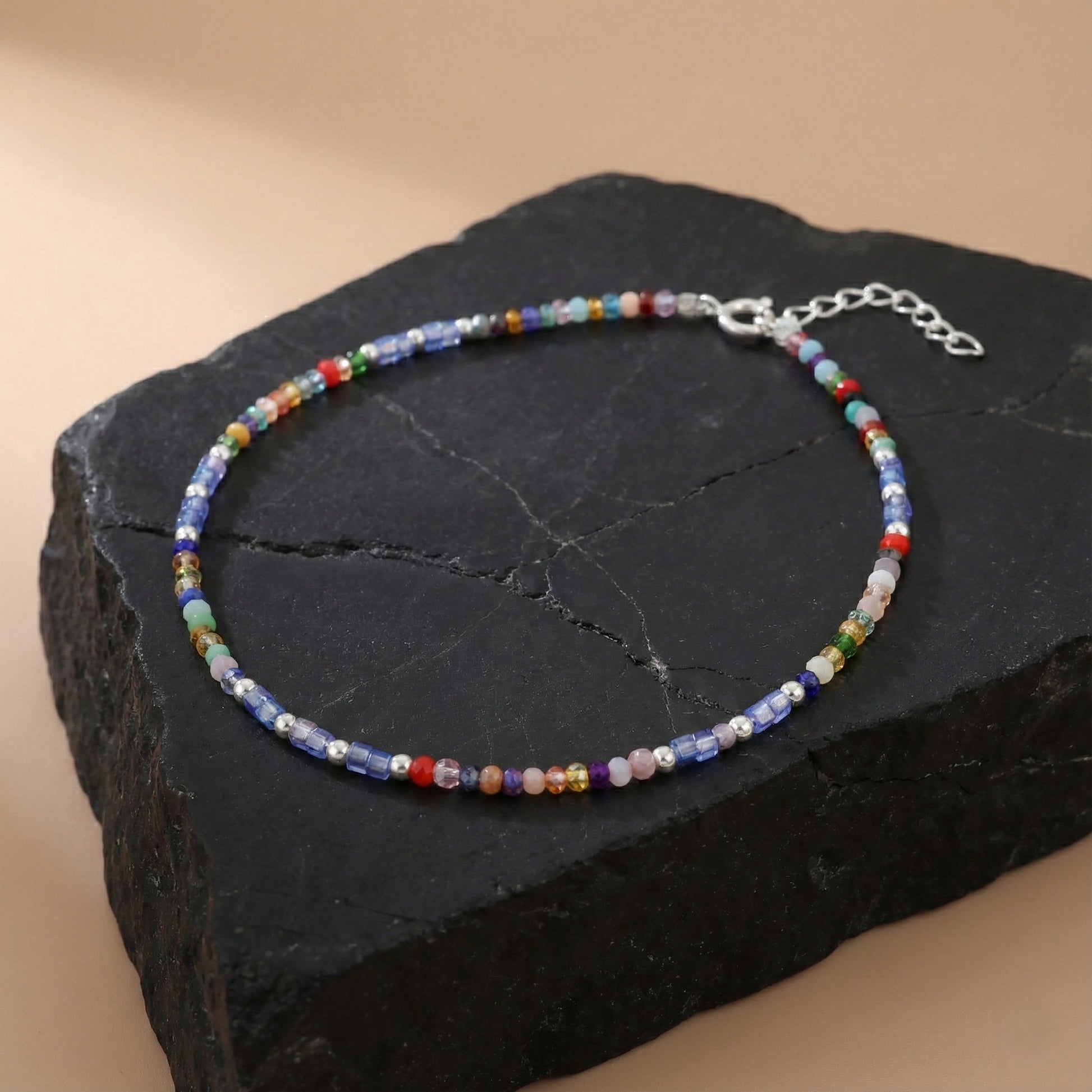 Multicolored beaded bracelet on a dark stone surface