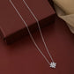 Silver necklace with a star-shaped pendant on a brown surface