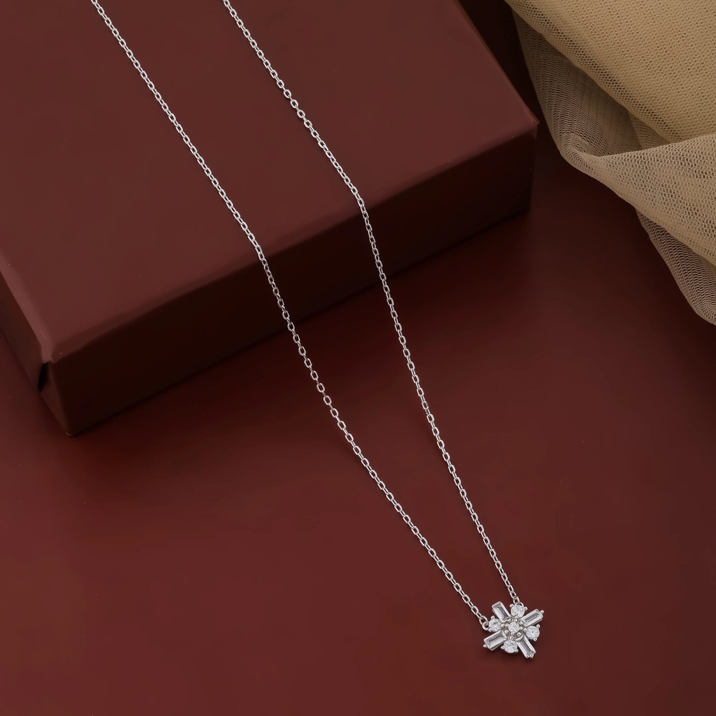 Silver necklace with a star-shaped pendant on a brown surface
