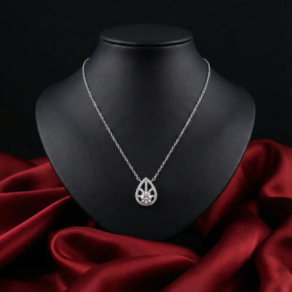 Silver necklace with a teardrop pendant on a black mannequin bust against a red fabric background