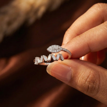 Close-up of a hand holding two diamond rings against a blurred background