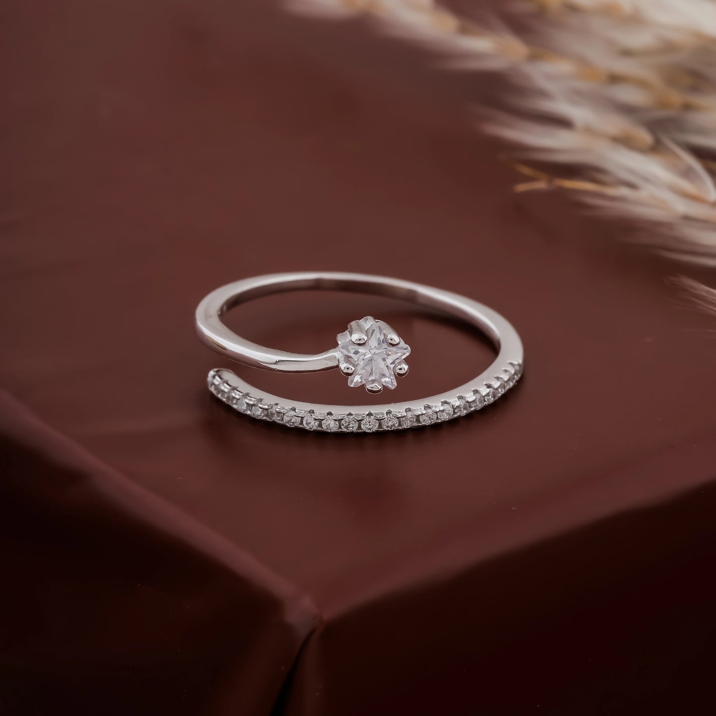 Silver ring with a diamond on a brown fabric background