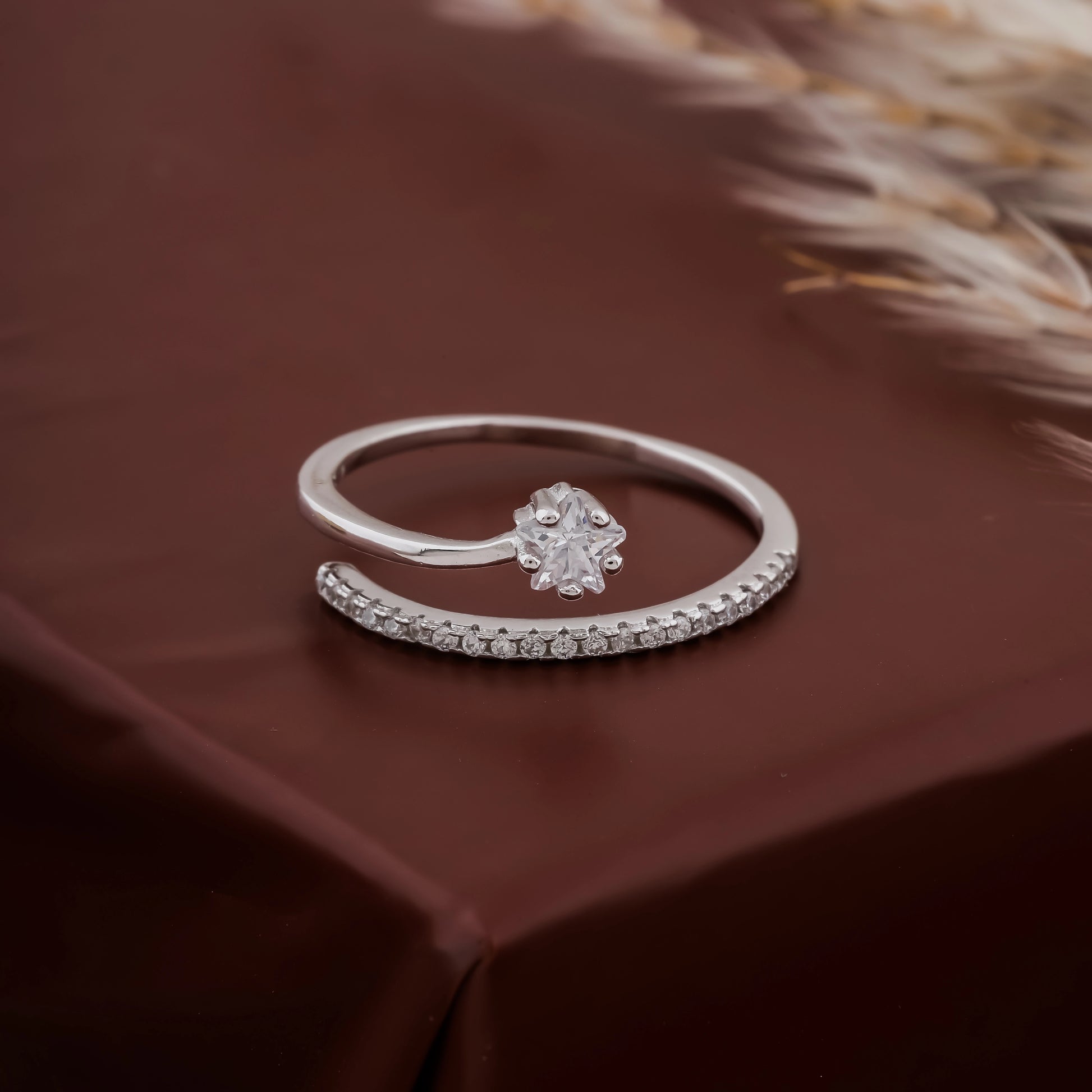 Silver ring with a diamond on a brown fabric background
