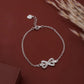 Silver bracelet with a bow charm on a brown background