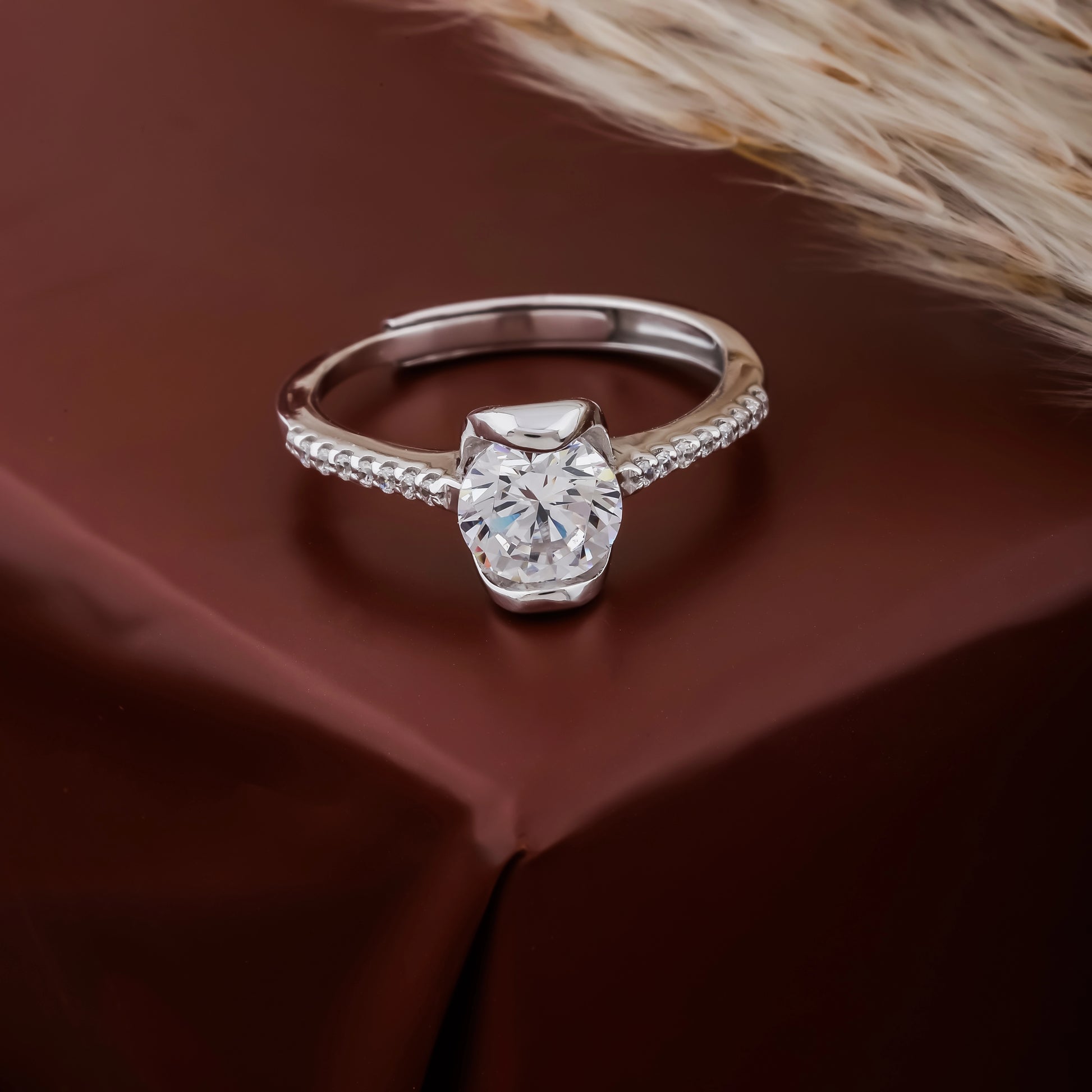 Silver ring with a large diamond on a brown fabric background
