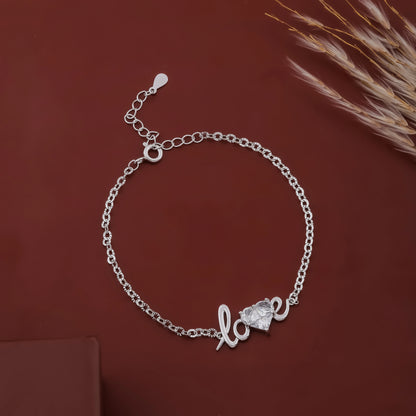 Silver bracelet with 'love' and heart design on a brown background