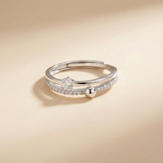 Silver ring with a small ball on a beige background