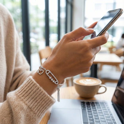 Person using a smartphone with a cup of coffee and laptop in the background