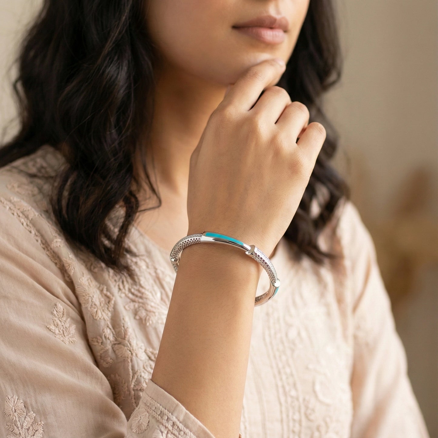 Woman wearing a silver bracelet with a blurred background