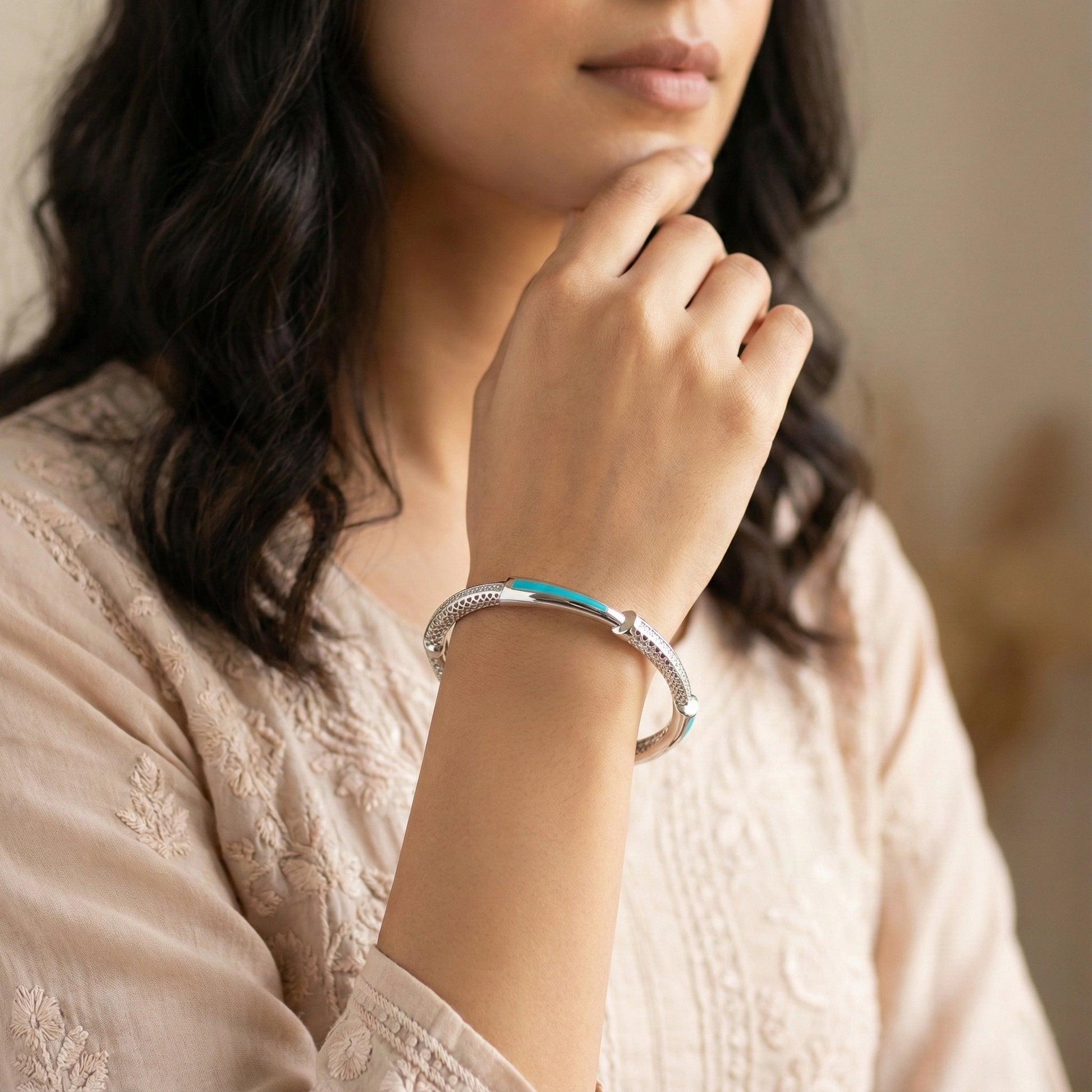 Woman wearing a silver bracelet with a blurred background