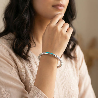 Woman wearing a silver bracelet with a blurred background
