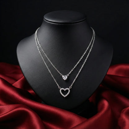 Silver heart-shaped necklace on a black mannequin bust with red fabric background