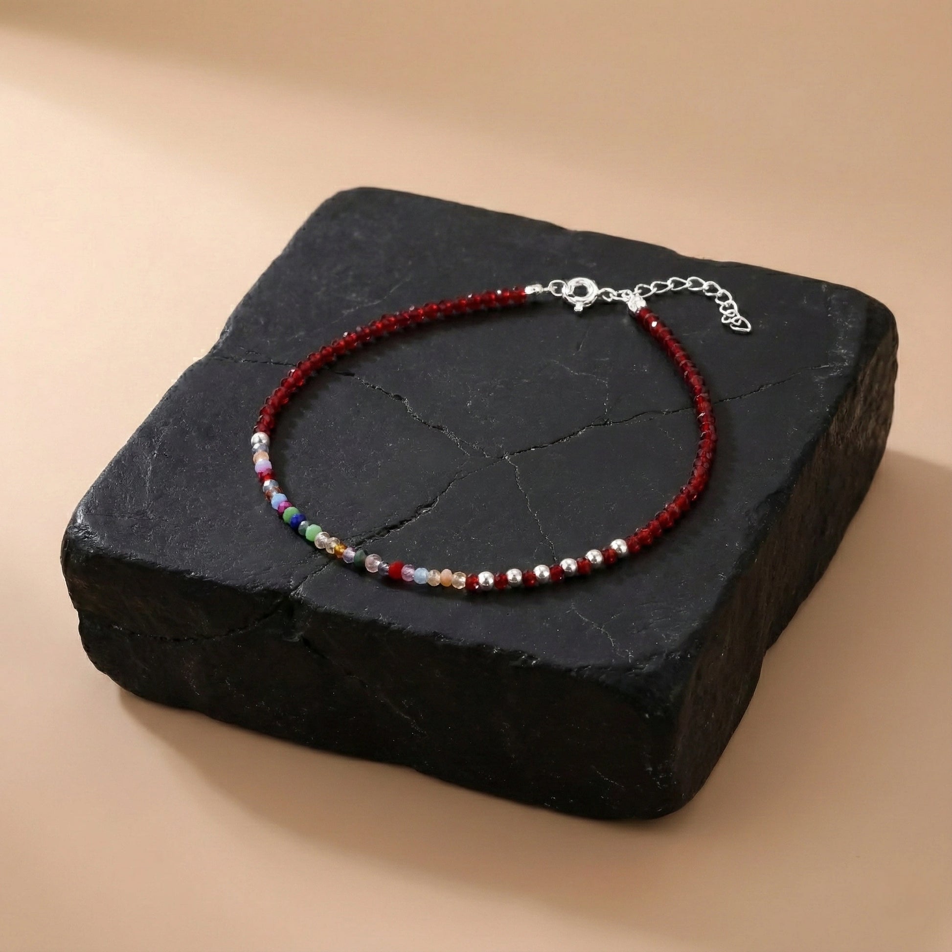 Multicolored beaded bracelet on a black stone surface