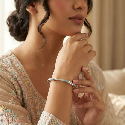 Woman wearing a silver bracelet, close-up of hand and arm.