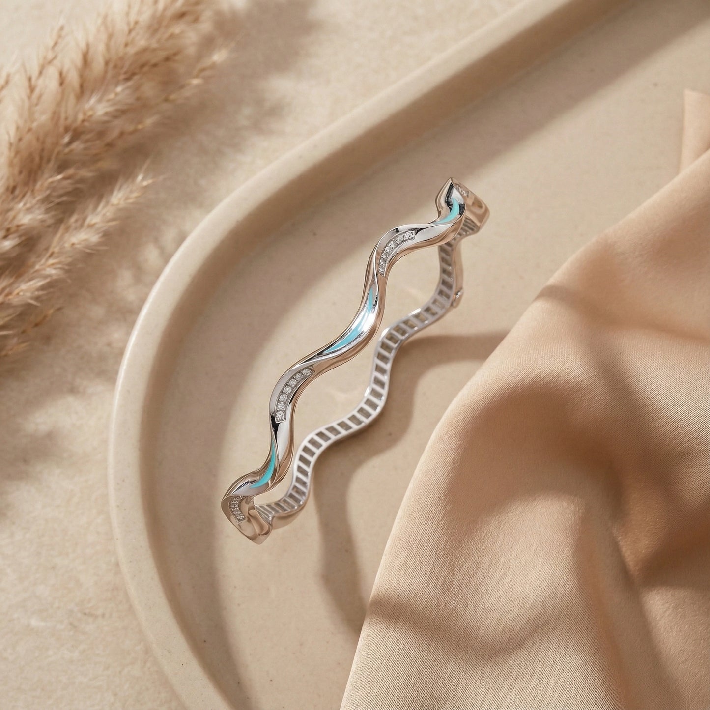 Silver earring on a beige surface with a soft focus background