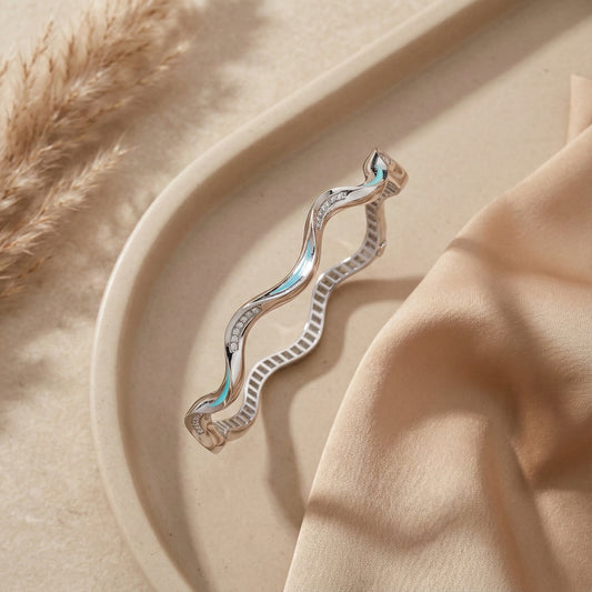 Silver earring on a beige surface with a soft focus background