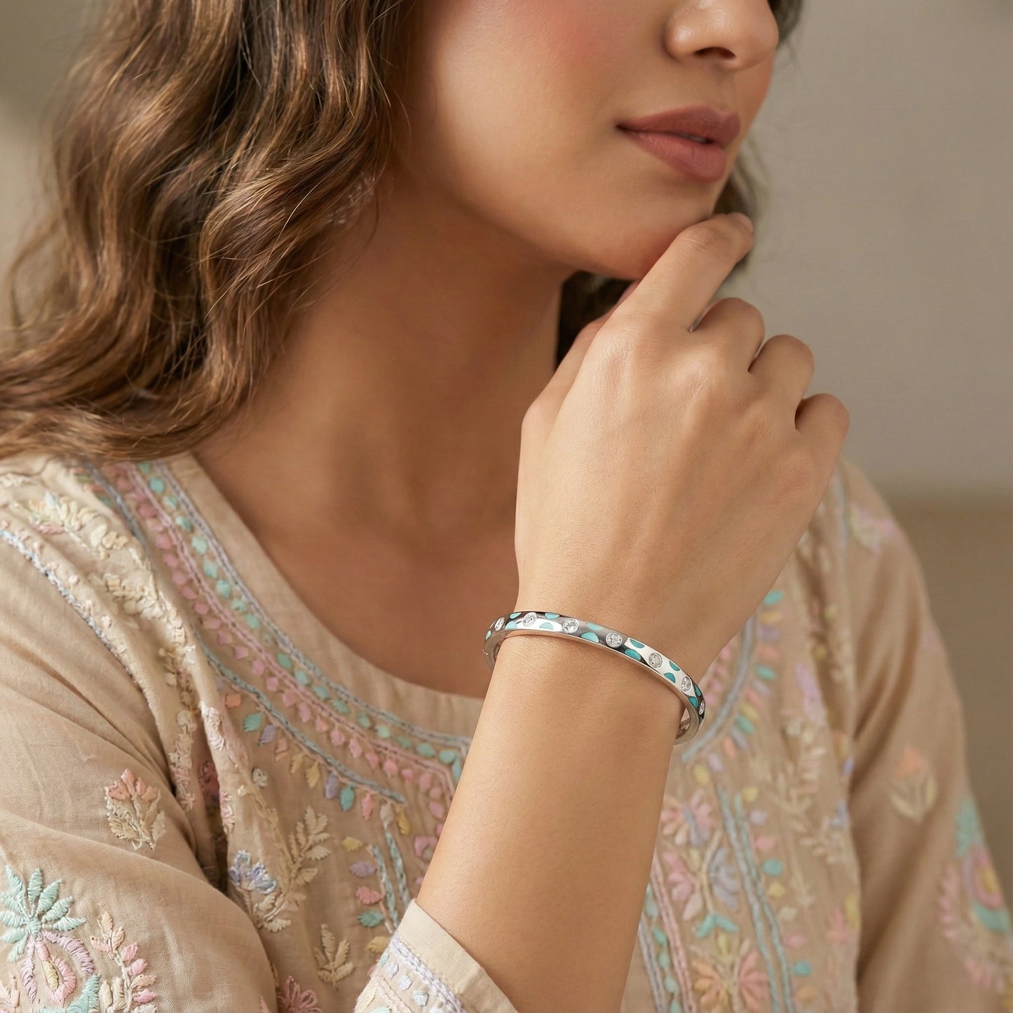Woman wearing a bracelet with an embroidered garment