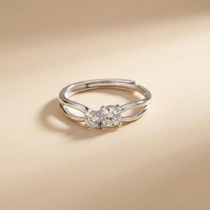 Silver ring with two diamonds on a beige background