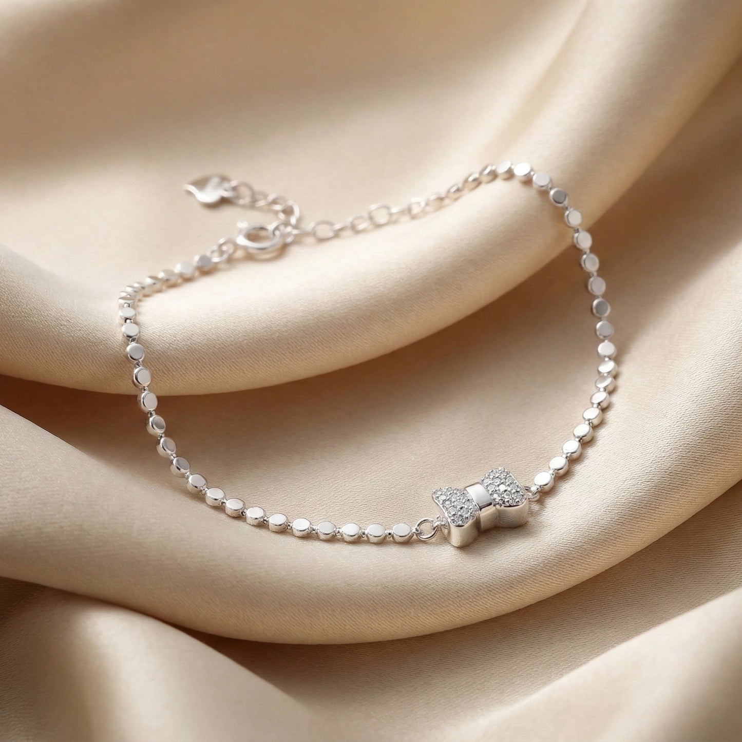 Silver bracelet with a star-shaped clasp on a beige fabric background