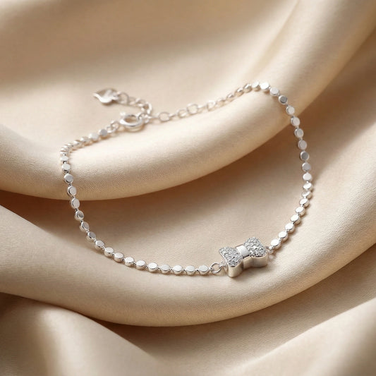Silver bracelet with a star-shaped clasp on a beige fabric background