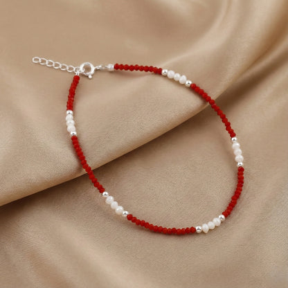 Beaded bracelet with red and white beads on a beige fabric background
