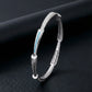 Silver bracelet with a blue accent on a dark background
