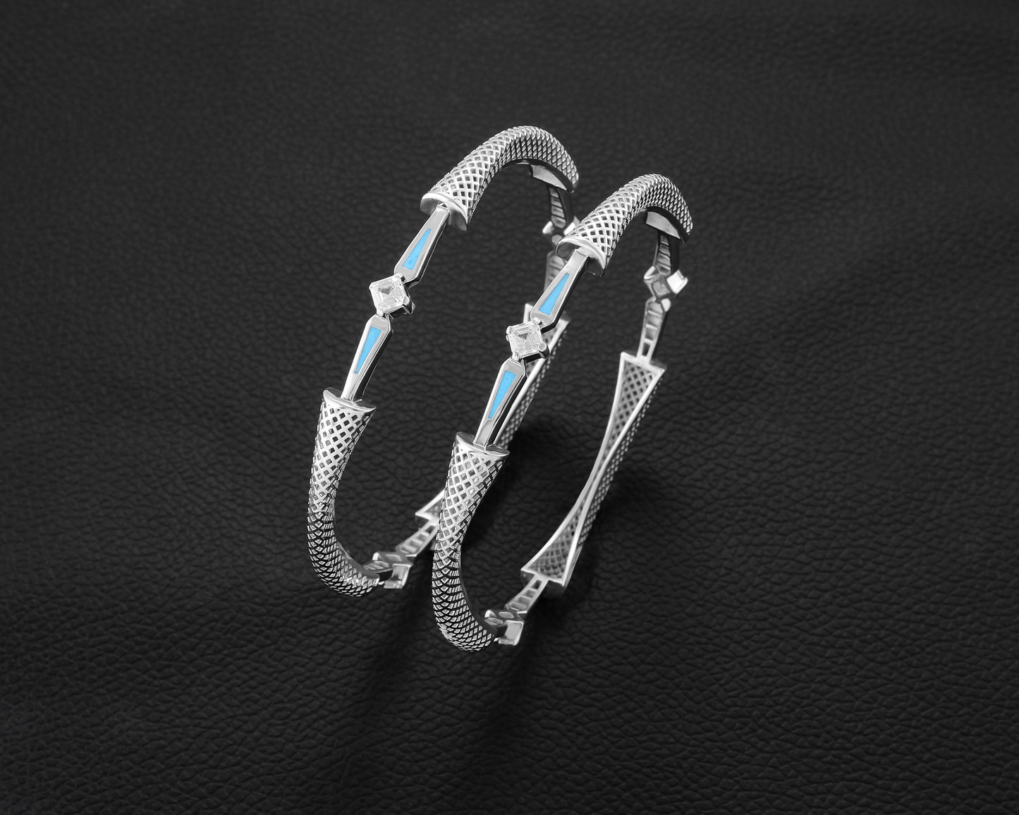 Silver bracelet with blue accents on a black textured background